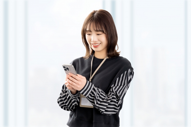 スマホを使う笑顔の女性